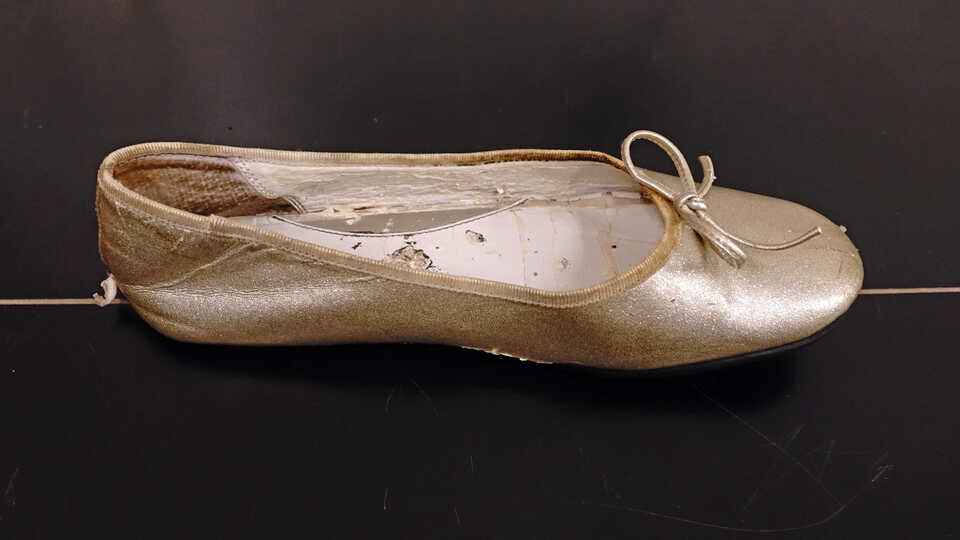A child's glittery ballet slipper style shoe