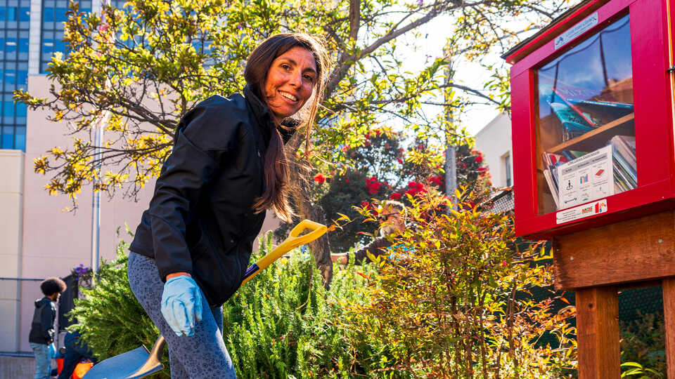 Cal Academy Chief of Education Estefanía Pihen González holds a shovel at a community event in the Tenderloin